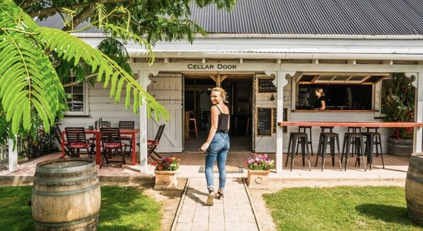 Een gebouw met opschrift 'CELLAR DOOR', met terras en een bar.