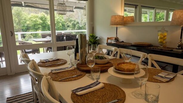 A dining area with a table set for four, including plates, cutlery, and glasses.