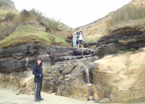 A rocky landscape with a small waterfall. - Omamari Beach / Kai iwi Lakes / Kauri Forest (Kai Iwi Lakes)