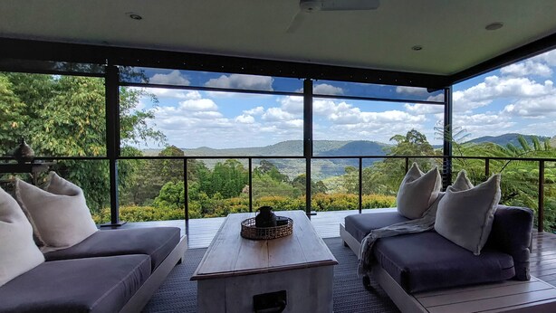 A balcony with a view of a mountainous landscape, furnished with two sofas and a small table. - Reconnect Your Mind, Body and Soul... (Wongawallan)