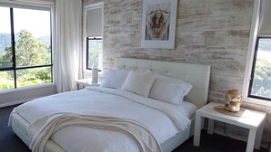 A bedroom with a large bed, a headboard, a bedside table, a framed artwork, and a view of the outdoors. - Reconnect Your Mind, Body and Soul... (Wongawallan)