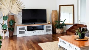 A living room with a flat-screen TV, wooden entertainment unit, and various plants. - Reconnect Your Mind, Body and Soul... (Wongawallan)
