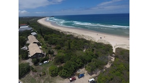 An aerial view of a beach with a row of houses, a sandy beach, and the ocean. - The Peninsula- 4bed Villa in Hastings Point (HASTINGS POINT)