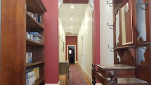 A hallway with a wooden bookshelf, a red carpet, and a wooden door with a mirror. - The Heritage - located in in the center of Glenelg (Glenelg)