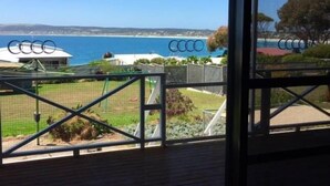 A view from a covered balcony overlooking a coastal area with a clear sky.