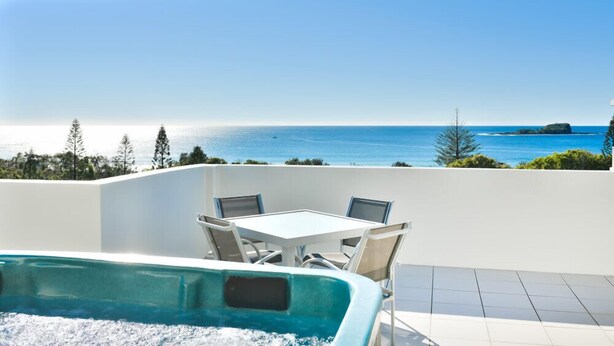 A pool area with a view of the ocean, a white table with chairs, and a tiled floor. - 3 Bedroom Penthouse Apartment with a Private Rooftop Spa (Sunshine Coast)