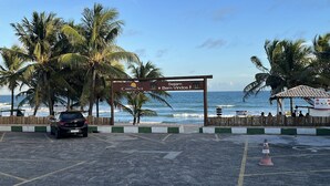 A parking area with a sign reading "Canto do Sol" and "Sejam Bem-Vindos". - Cozy and charming house with pool and gardens in a beachfront condominium! (Camaçari)