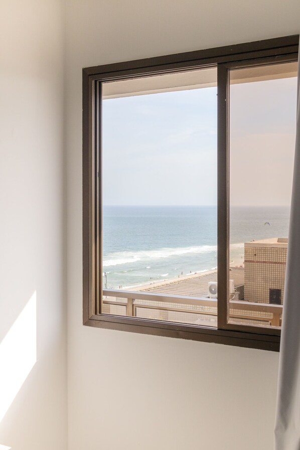 A window with a view of the beach and ocean. - Barra Leme Ocean View (Rio de Janeiro)