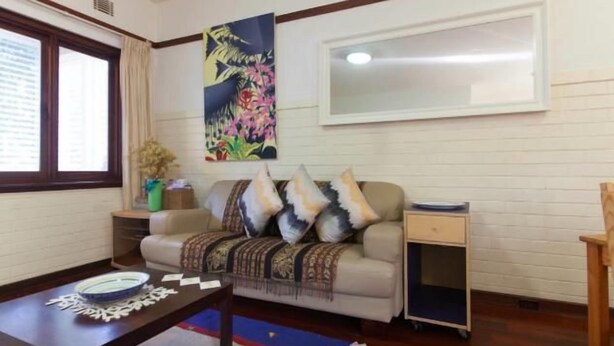 A living room with a sofa, a coffee table, a side table, a painting, and a window. - B4 UWA, Swan River, Hospitals, CBD (Crawley)