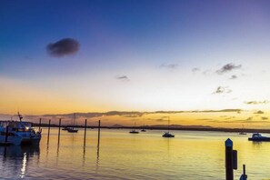 Un port de plaisance au coucher du soleil, avec des bateaux amarrés.