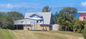 A two-story house with a flat roof and a balcony. - Arbour Rest Expansive Ocean Views (Agnes Water)
