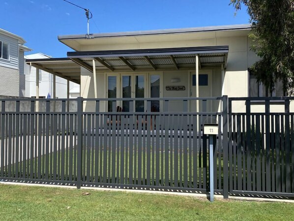 A building with a covered entrance and a fenced yard.