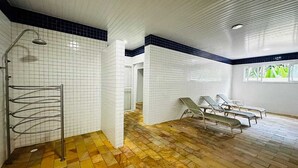 A swimming pool area with tiled walls, a shower, and lounge chairs. - Ubatuba coverage for families - up to 12 people (including babies and children) (Ubatuba)