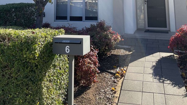 A modern two-story building with a white facade, large windows, and a door with a glass panel. - Queen Lizzy Townhouses | 3BR, Parking, WiFi, Alfresco | City & Coast (Woodville South)