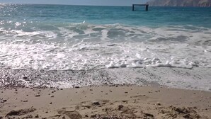A beach with clear water, pebbles, and a structure in the distance. - Beachfront, free wi-fi, A/C, free parking (Baška)