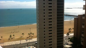 Un edificio alto con vista a la playa y al océano.