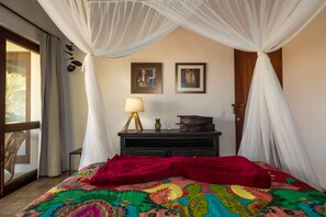 A bedroom with a bed, a nightstand, a lamp, a dresser, and two framed pictures on the wall. - Vila do Outeiro em frente a praça da igreja (Porto Seguro)