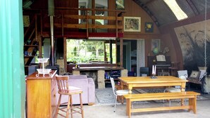 L’intérieur d’un chalet rustique, avec une table à manger en bois, des chaises, un canapé et une cheminée.