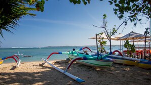 A beach with boats and umbrellas. - La Bali 4 Bedrooms Villa Sanur (Denpasar Selatan)