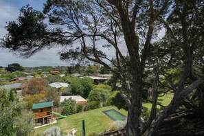 A residential area with houses, a large tree, and a well-maintained lawn.