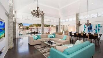 A spacious living room with a sectional sofa, a coffee table, and a dining area with a table and chairs.