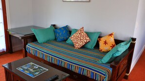 A cozy living room with a sofa, a glass coffee table, and a remote control. - Hatcher's Manor Richmond - Farmhouse (Richmond TAS)