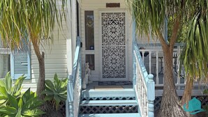A white building with a decorative gate and steps leading to a porch. - Bromyard Lakeside Cottage - access to waterfront (Swansea)