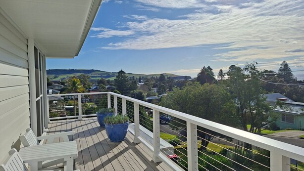 A balcony with a view of a residential area, including houses and greenery. - Werri Escape - walk to the beach (Gerringong)