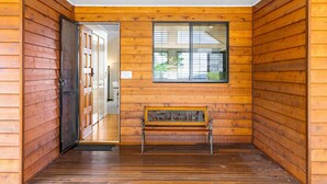 Un intérieur en bois avec un banc, une porte et une fenêtre.