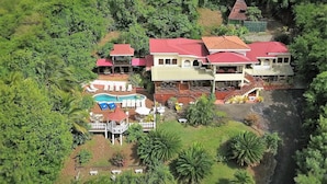 A large resort with multiple buildings, a swimming pool, and lush greenery. - Sea view, fully staffed villa for Families & Retreats, groups of 9 - 20 guests (Cap Estate)