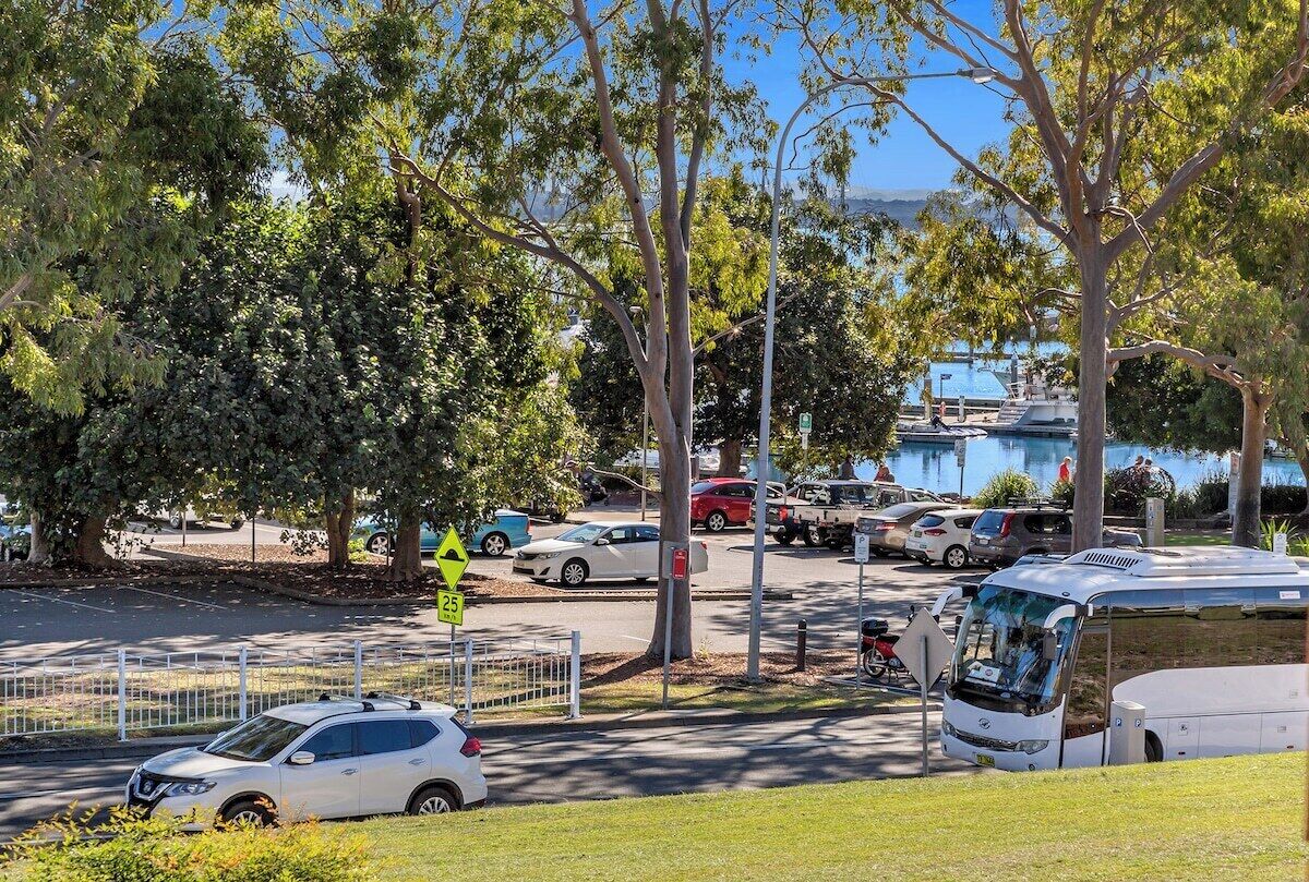 A parking area with cars, a bus, and a pedestrian walkway.