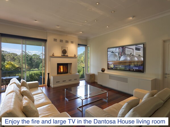 A spacious living room with a fireplace, large TV, and comfortable seating.