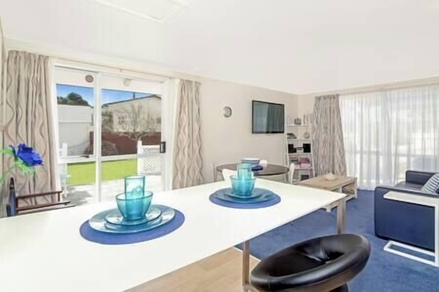 Une chambre d’hôtel dotée d’un coin repas, d’un téléviseur fixé au mur et offrant une vue sur l’extérieur par la fenêtre.