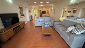 A living room with a TV, sofa, and coffee table. - COMPASS PT 5 - HAMILTON ISLAND - GREAT BARRIER REEF - WHITSUNDAYS - WHITEHAVEN (Hamilton Island)