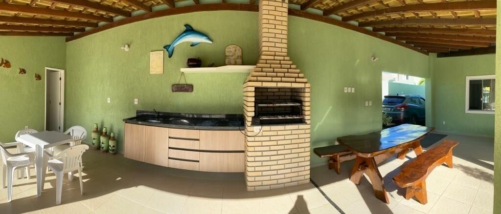 A kitchen with a brick oven, a dining table, and chairs.