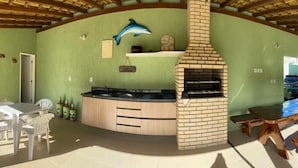 Una cocina con un horno de ladrillo, una mesa de comedor y sillas.