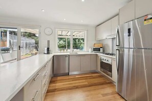 A modern kitchen with stainless steel appliances, a dishwasher, and a large refrigerator.