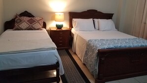A hotel room with two single beds, a nightstand with a lamp, and a wooden headboard. - HOLA SOY SERENA, MI PROPIEDAD  SE LLAMA  "CASA SERENA" (GUAYAQUIL)
