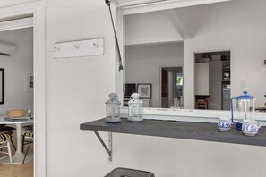 A kitchen with a black countertop, white cabinets, and a window with a view of the interior.