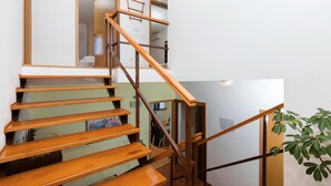 Eine Holztreppe mit Handlauf, die zu einer oberen Etage führt.