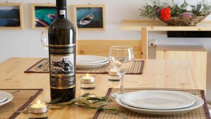 A dining table set with plates, a wine bottle, and candles. - G Living 365 (Kefalonia)