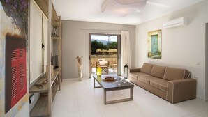 A living room with a sofa, a coffee table, and a view of the outdoors through a large window. - G Living 365 (Kefalonia)