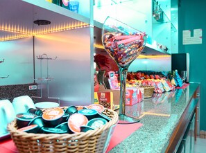 A buffet area with a variety of food items, including a basket of condiments and a decorative glass bowl filled with snacks. - Amapa Hotel (Macapa)