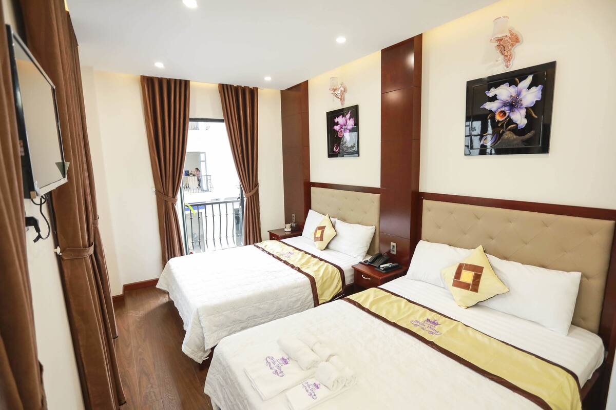 Une chambre d’hôtel avec deux lits, un grand miroir et une vue sur le balcon extérieur.