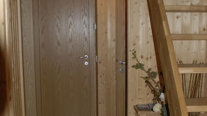 A wooden staircase leading to a door with a small plant beside it. - Vorsabær 2 Holiday Home (Selfoss)