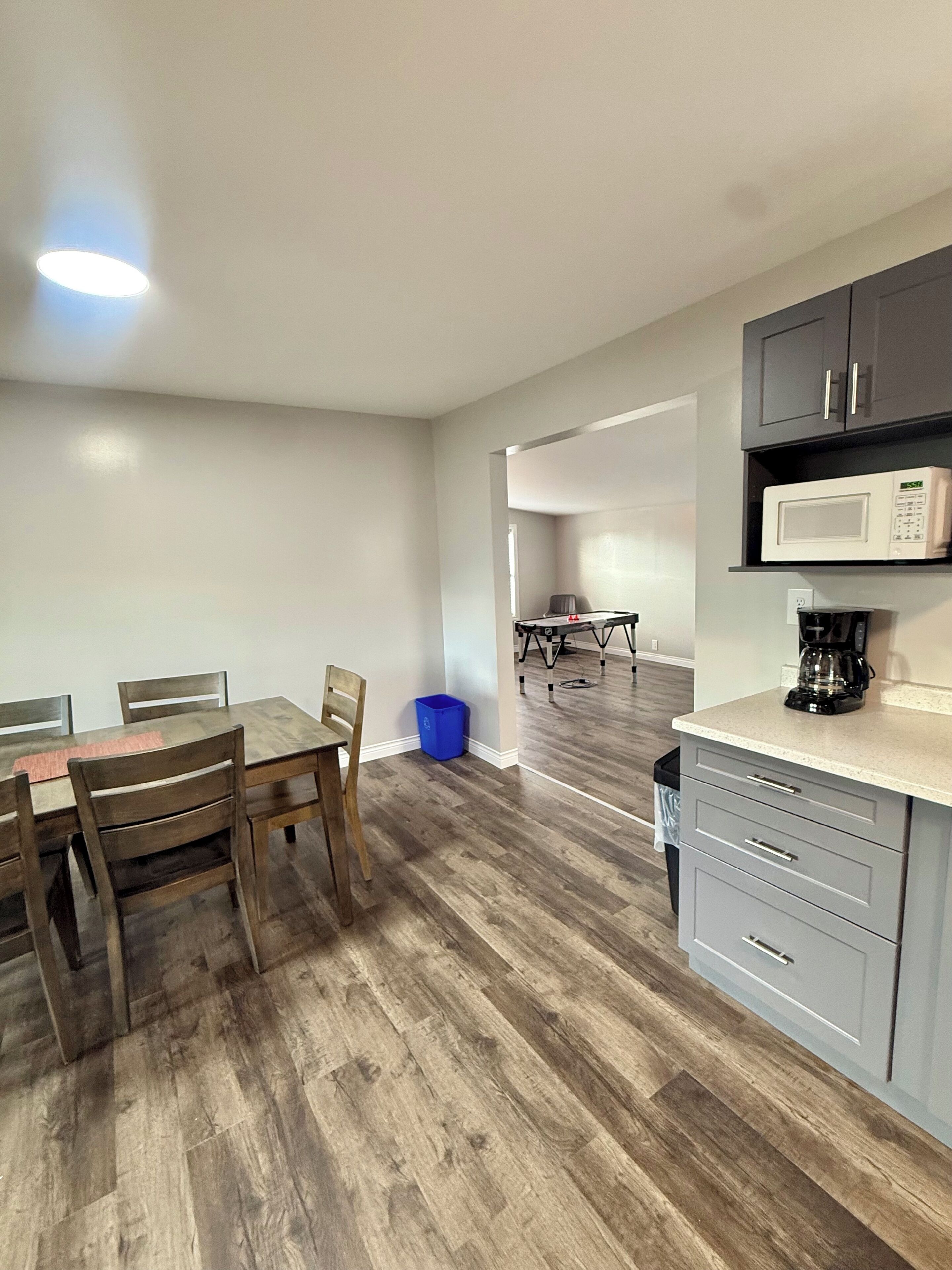 Una cucina moderna con zona pranzo, pavimento in legno ed elettrodomestici integrati.