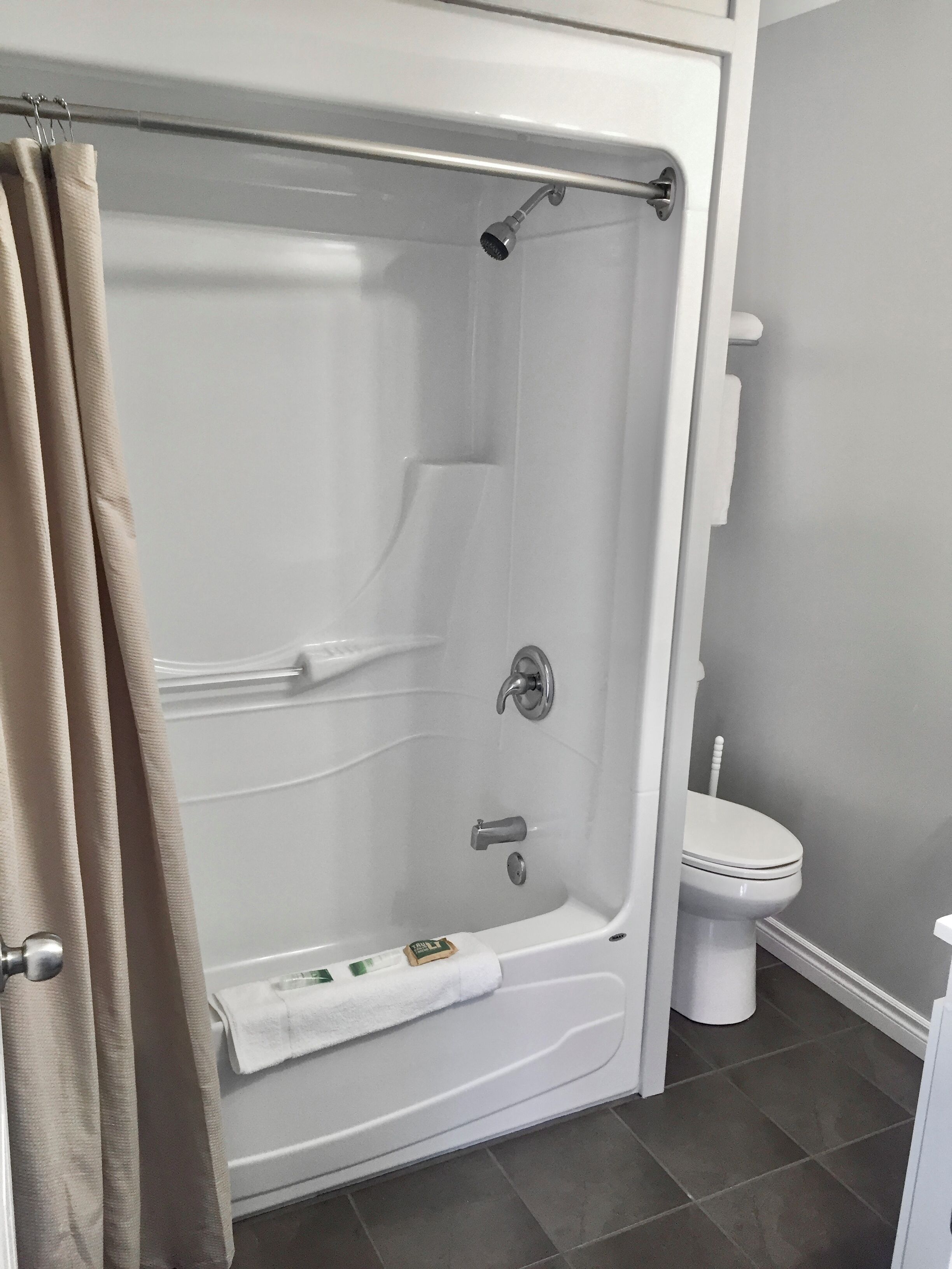 Un baño con bañera, inodoro y cortina de ducha.