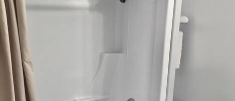 Un baño con bañera, inodoro y cortina de ducha.