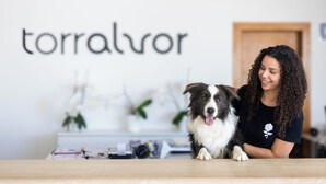 A person with a dog in a room with a white wall displaying the word "torralvor". - Dunas do Alvor - Torralvor (Portimão)