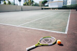 A tennis court with a tennis racket and ball.